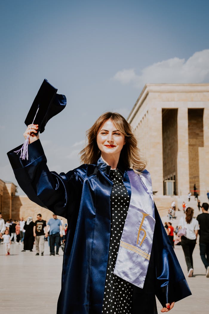Graduate holding mortarboard at Anitkabir, celebrating her graduation on a sunny day.